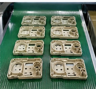 Injection molded plastic parts after demolding on production conveyor