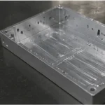 Side view of CNC machined aluminum housing with clean holes, slots, and precision machined surfaces