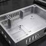 Detailed view of the front panel of a CNC machined aluminum enclosure with threaded holes and precision cut openings