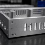 Close-up detail of a CNC machined aluminum enclosure with clean edges, ventilation slots, and threaded holes