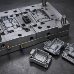Zinc alloy die casting mold with sample electronic components on a workshop table